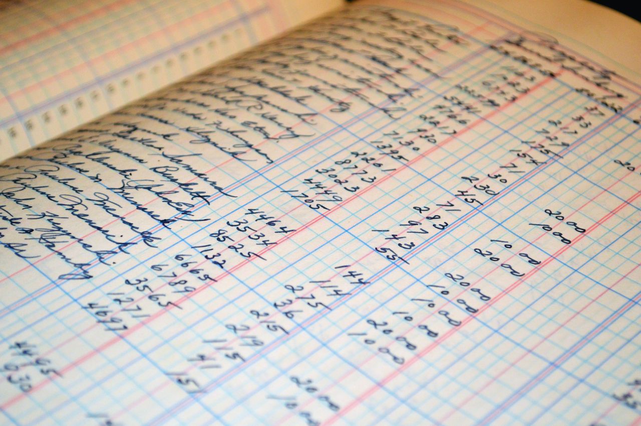 Handwritten figures in the columns of an old ledger