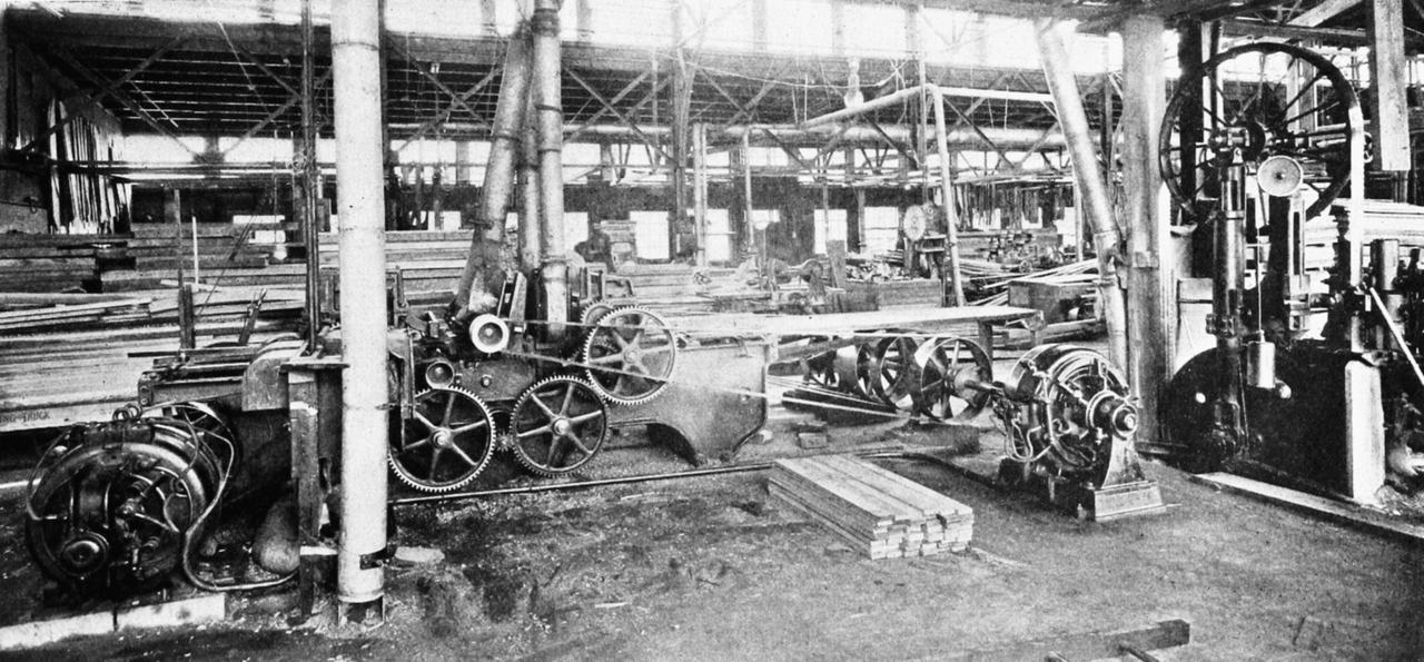 A planing mill in 1903 with electric motors standing on the floor beside the machines, driving them directly rather than from an overhead shaft.