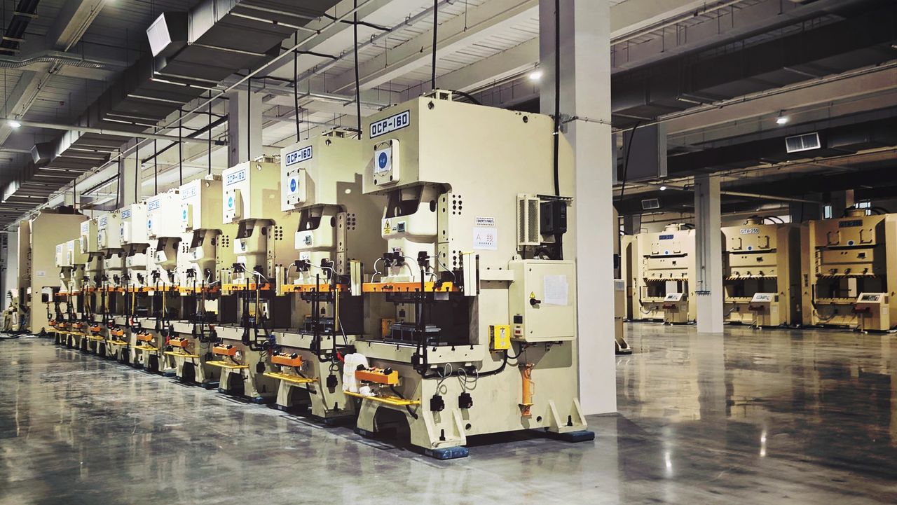 A row of power presses on a factory floor, each with its own drive